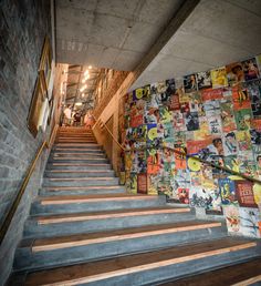 there are many pictures on the wall next to the stair case in this building that is decorated with graffiti