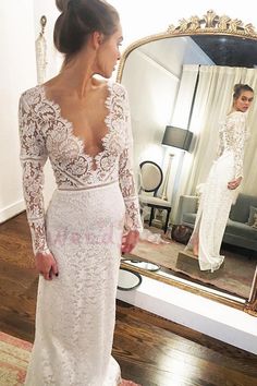 a woman is looking at her wedding dress in the mirror