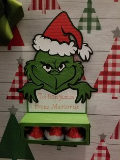 a green shelf with some red balls in it and a santa hat on the top