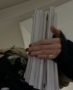 a woman's hand holding stacks of papers