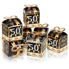 four black and gold gift boxes with golden ribbons on the top, one for 50th birthday