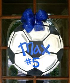 a soccer ball with the number 5 painted on it is hanging in a window sill