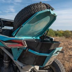 the back end of a blue motorcycle with its trunk open and it's seat up