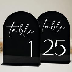 two black acrylic table numbers with white lettering