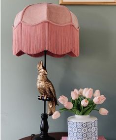 a table with a lamp and flowers on it