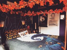 a bedroom decorated for halloween with decorations on the ceiling and lights hanging from the ceiling