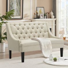 a living room scene with focus on the tufted couch and rugs in the foreground