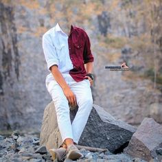 a young man sitting on top of a rock