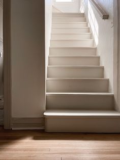 a set of white stairs leading up to an open door