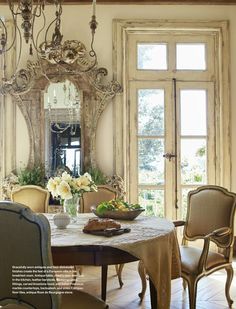 a dining room table with chairs and a mirror on the wall in front of it