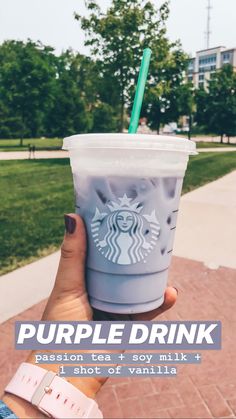 a person holding up a starbucks drink with the words purple drink in front of them