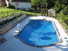 an above ground swimming pool surrounded by landscaping