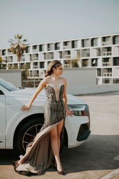 a woman standing next to a white car