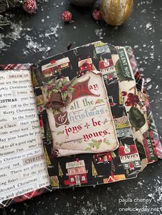 an open book with christmas decorations around it