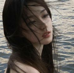 a woman with long hair standing in the water