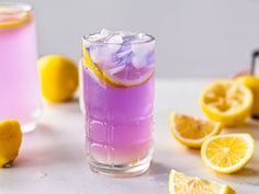 two glasses filled with purple liquid and lemons