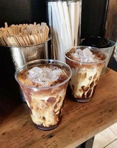 two glasses filled with ice cream on top of a wooden table