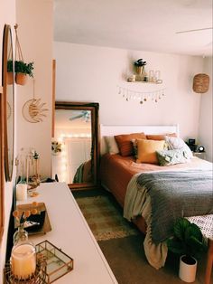 a bed room with a neatly made bed next to a mirror and lights on the wall