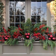 a window box filled with christmas decorations and greenery