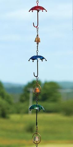 a wind chime hanging from the side of a building with trees in the background