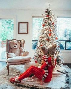 a christmas tree with red and white striped stockings on it next to a teddy bear