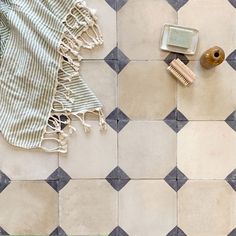 a towel, brush and comb on a tiled floor