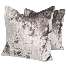 two gray velvet pillows on a white background, one is made from crushed fabric and the other has an old - fashioned design