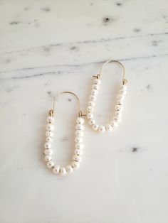 ∙These pearl hoop earrings are super femme and perfect for dressing up a simple outfit! Would also be wonderful for a bride with a bit of vintage flair. ∙Unique shape is sure to catch you some compliments. ∙Nice and lightweight on the ear! ∙Top quality materials are excellent for sensitive ears/skin. ∙These measure ~2.25 inches long. ~M A T E R I A L S ~ Choose from- * 925 Sterling silver *14k Gold fill *14k Rose gold fill **What is 14k Gold-fill?** Gold fill does not tarnish or wear off and con Elegant Pearl Chain Hoop Earrings For Wedding, Elegant Hoop Earrings With Pearl Chain For Wedding, White Pearl Embellished Hoop Earrings For Wedding, White Pearl Drop Hoop Earrings In 14k Gold, Feminine Pearl Chain Earrings For Wedding, Wedding Pearl White Hoop Earrings, Chic 14k Gold Filled Jewelry For Wedding, White 14k Gold Filled Bridal Earrings For Wedding, Small Hoop Pearl Chain Wedding Jewelry