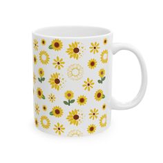 a white coffee mug with sunflowers on the front and sides, all in yellow