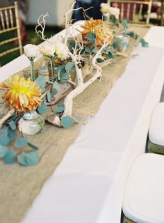 the table is set with flowers and candles