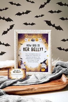 a wooden tray topped with halloween decorations next to a sign that says how big is her belly?