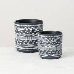 two black and white cups sitting next to each other