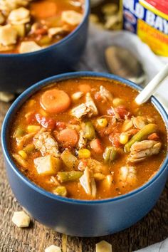 two bowls of chicken and vegetable soup on a table