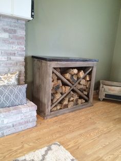 a firewood storage unit sitting on top of a hard wood floor next to a pillow