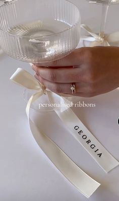 a person holding a wine glass in their hand with ribbon around it and the words, personalized ribbons