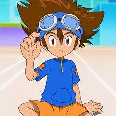 a young boy wearing goggles sitting on top of a tennis court