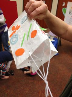 a person holding a bag with an orange flower on it in front of other people