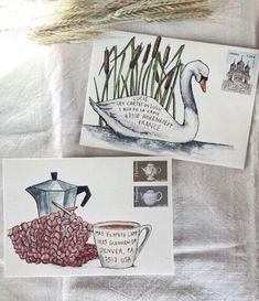 two envelopes with stamps on them sitting next to some water plants and a teapot