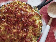 a pizza sitting on top of a pan next to a wooden spoon