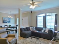 a living room filled with furniture and a ceiling fan