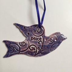 a metal bird ornament hanging on a blue ribbon