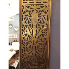 an ornate gold metal door in the corner of a room with purple walls and furniture