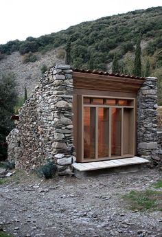 a small building made out of rocks on the side of a hill