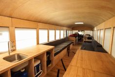 the inside of a camper with wood flooring and counter space for cooking food