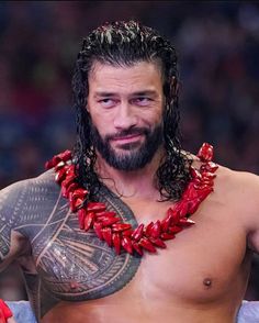 a man with long hair and beard wearing a red beaded necklace on his neck