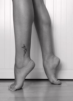 a woman's legs with a small tattoo on her lower leg and the bottom part of her body