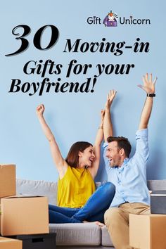 a man and woman sitting on top of a couch with their hands up in the air