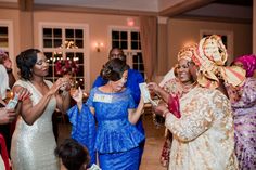 a group of women standing around each other in front of a crowd at a wedding