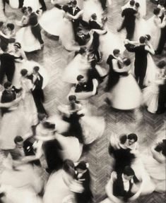 a black and white photo of people dancing on the dance floor with their arms around each other