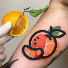 a man with a tattoo on his arm holding an orange